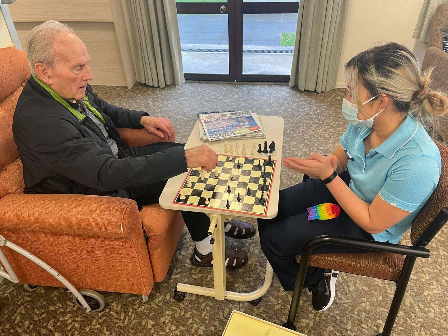 Resident and staff member play chess together